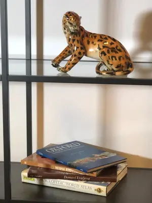 a book shelf with a toy cheetah sitting on top of books at Comfortable and spacious apartment in one of Belgrade’s most exclusive neighbourhoods in Belgrade
