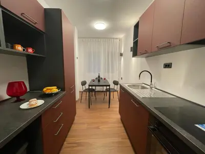 a kitchen with purple cabinets and a table in the background at Comfortable and spacious apartment in one of Belgrade’s most exclusive neighbourhoods in Belgrade
