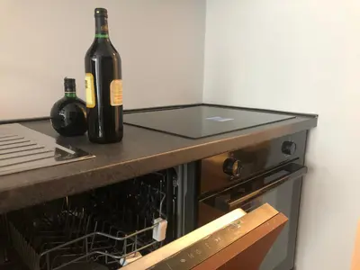 a bottle of wine sitting on a counter next to an oven at Comfortable and spacious apartment in one of Belgrade’s most exclusive neighbourhoods in Belgrade