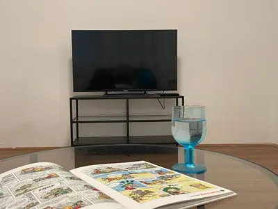 a table with a book and a glass of wine at Comfortable and spacious apartment in one of Belgrade’s most exclusive neighbourhoods in Belgrade