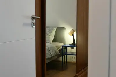 a room with a chair and a lamp on a table at Comfortable and spacious apartment in one of Belgrade’s most exclusive neighbourhoods in Belgrade