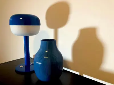 a blue vase and a lamp on a table at Comfortable and spacious apartment in one of Belgrade’s most exclusive neighbourhoods in Belgrade