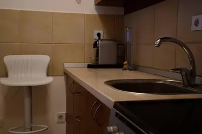 a kitchen with a sink and a chair in it at Royalux Zemun Residences in Belgrade