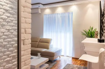 a living room with a couch and a window at Royalux Zemun Residences in Belgrade