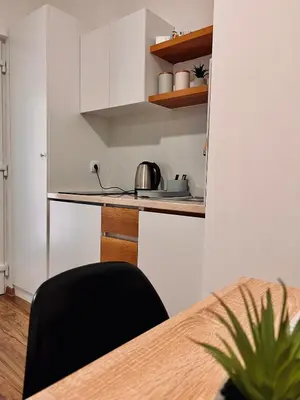 a kitchen with a table and a black chair at Dani Lux Belgrade Center Studio Apartment in Belgrade