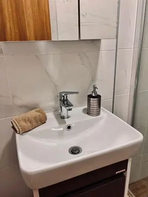 a white sink in a bathroom with a mirror at Dani Lux Belgrade Center Studio Apartment in Belgrade