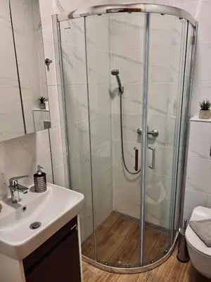 a shower stall in a bathroom with a sink at Dani Lux Belgrade Center Studio Apartment in Belgrade