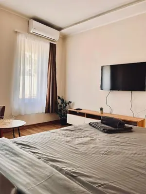 a bedroom with a bed and a flat screen tv at Dani Lux Belgrade Center Studio Apartment in Belgrade