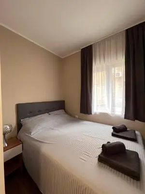 a bedroom with a large white bed with a window at Stefan Suite Belgrade Center Apartment in Belgrade