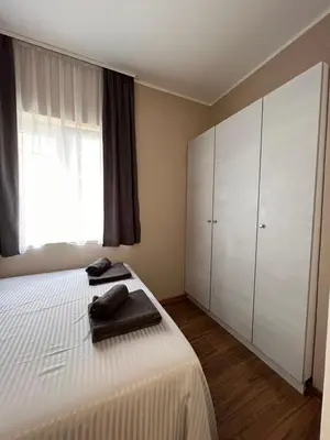 a bedroom with a white bed and a large window at Stefan Suite Belgrade Center Apartment in Belgrade