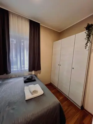 a bedroom with a bed and a large window at Stefan Suite Belgrade Center Apartment in Belgrade