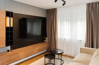 a living room with a large flat screen tv at Royalux Kennedy Residences in Tošin Bunar