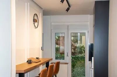 a kitchen with a table and chairs and a window at Royalux Kennedy Residences in Tošin Bunar