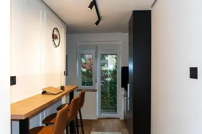 a kitchen with a table and chairs and a window at Royalux Kennedy Residences in Tošin Bunar