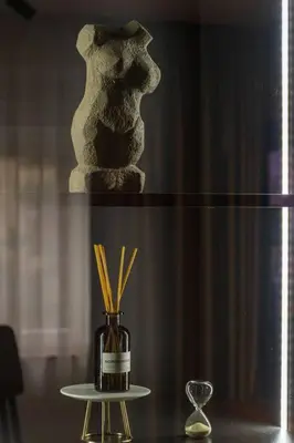 a vase with straws in it sitting on a table at Royalux Kennedy Residences in Tošin Bunar