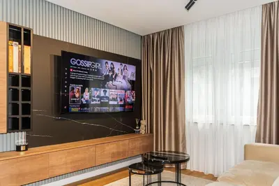 a living room with a flat screen tv on a wall at Royalux Kennedy Residences in Tošin Bunar