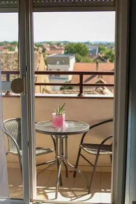 a small table with a plant on a balcony at Apartman San in Ruma