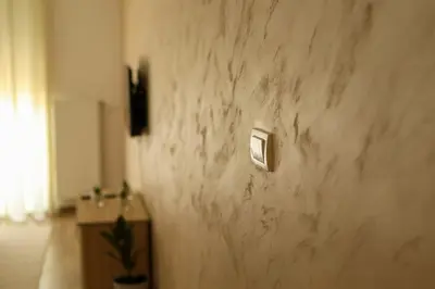 a white marble wall with a switch on it at Apartman San in Ruma