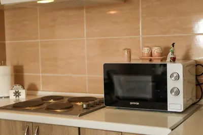 a microwave sitting on top of a stove in a kitchen at Apartman San in Ruma