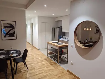 a kitchen and dining room with a table and a mirror at Luxury Belgrade Waterfront top floor Apt with an amazing view in Belgrade