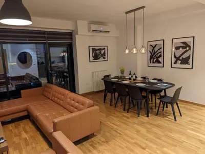 a living room with a couch and a table with chairs at Luxury Belgrade Waterfront top floor Apt with an amazing view in Belgrade