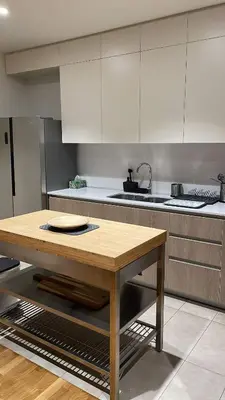 a kitchen with a wooden table in the middle at Luxury Belgrade Waterfront top floor Apt with an amazing view in Belgrade