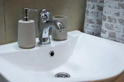 a sink with a faucet and two cups on it at Sava centar-Arena, apartman EMA in Novi Beograd