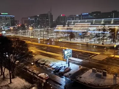a city at night with cars parked in a parking lot at Sava centar-Arena, apartman EMA in Novi Beograd