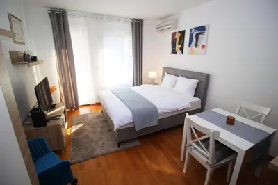 a small bedroom with a bed and a table at Apartman Bizmark in Novi Beograd