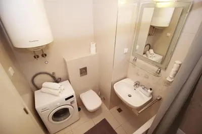 a small bathroom with a sink and a washing machine at Apartman Bizmark in Novi Beograd