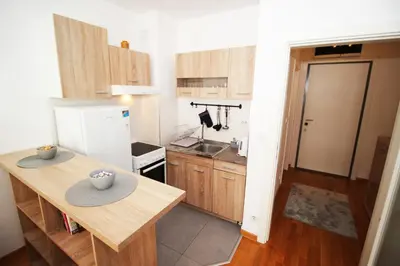 a kitchen with a wooden table and a white refrigerator at Apartman Bizmark in Novi Beograd