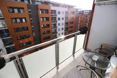a balcony with a table and chairs and buildings at Apartman Bizmark in Novi Beograd