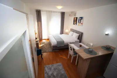 a small bedroom with a bed and a desk and a table at Apartman Bizmark in Novi Beograd