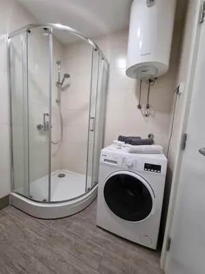 a washing machine in a bathroom with a shower at Urban studio in Bežanija