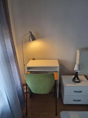 a desk with a green chair and a lamp at Urban studio in Bežanija