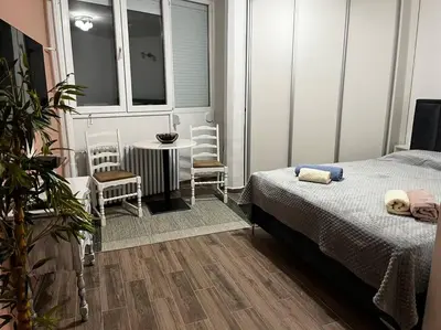 a bedroom with a bed and a table and chairs at Squeeze The Day in Belgrade