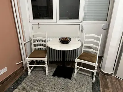 a small table with two chairs and a bowl on it at Squeeze The Day in Belgrade