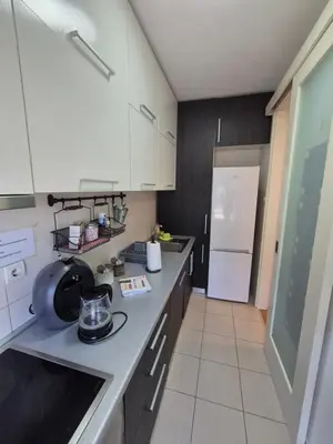 a kitchen with white cabinets and a white refrigerator at Neven in Novi Beograd