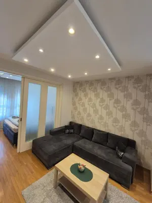 a living room with a black couch and a table at Neven in Novi Beograd
