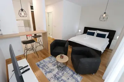 a small apartment with a bed and a table and chairs at Savada BLUE - apartman na Novom Beogradu sa parkingom doplata 5 evra dan in Belgrade