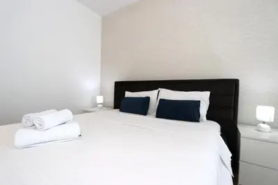 a bedroom with a white bed with towels on it at Savada BLUE - apartman na Novom Beogradu sa parkingom doplata 5 evra dan in Belgrade