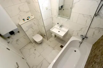 a white bathroom with a sink and a tub and a toilet at Savada BLUE - apartman na Novom Beogradu sa parkingom doplata 5 evra dan in Belgrade