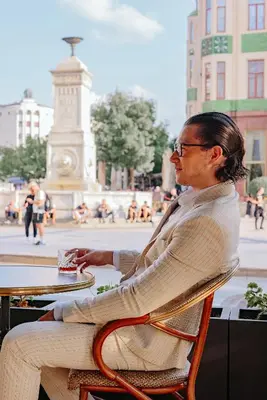 a man in a suit sitting at a table in front of a fountain at Hotel Balkan in Belgrade