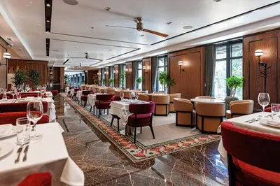 a restaurant with tables and chairs in a room at Hotel Balkan in Belgrade
