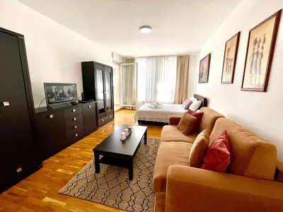 a living room with a couch and a bed at Modesti - stan na dan Novi Beograd sa parkingom 5 evra po danu in Belgrade
