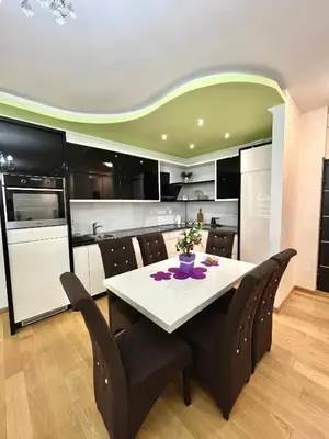 a kitchen with a white table and black chairs at Apartment Delic in Belgrade