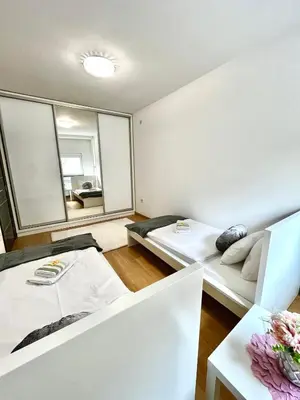 a room with two beds and a couch and a mirror at Apartment Delic in Belgrade