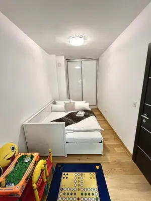 a bedroom with a bed and a table with a playmat at Apartment Delic in Belgrade
