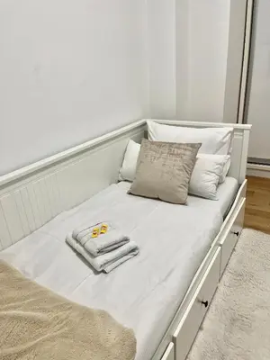 a bed with two towels and a pair of scissors on it at Apartment Delic in Belgrade
