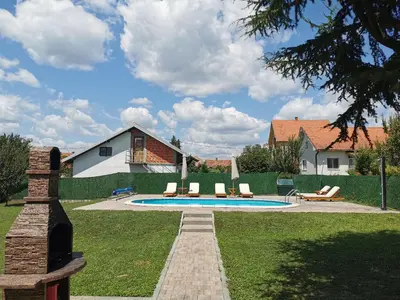 a swimming pool in a yard with chairs and a house at Big Borak in Veliki Borak